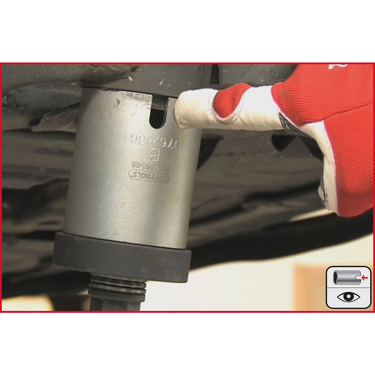 Person mit rotem Handschuh berührt ein silbernes Werkzeug mit schwarzen und grauen Elementen.